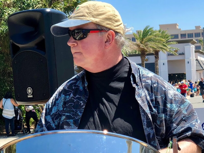 Picture of Mike Wilson playing a steel drum on the back of a float during the Opening of the Beaches Parade in Jacksonville Beach, Florida.